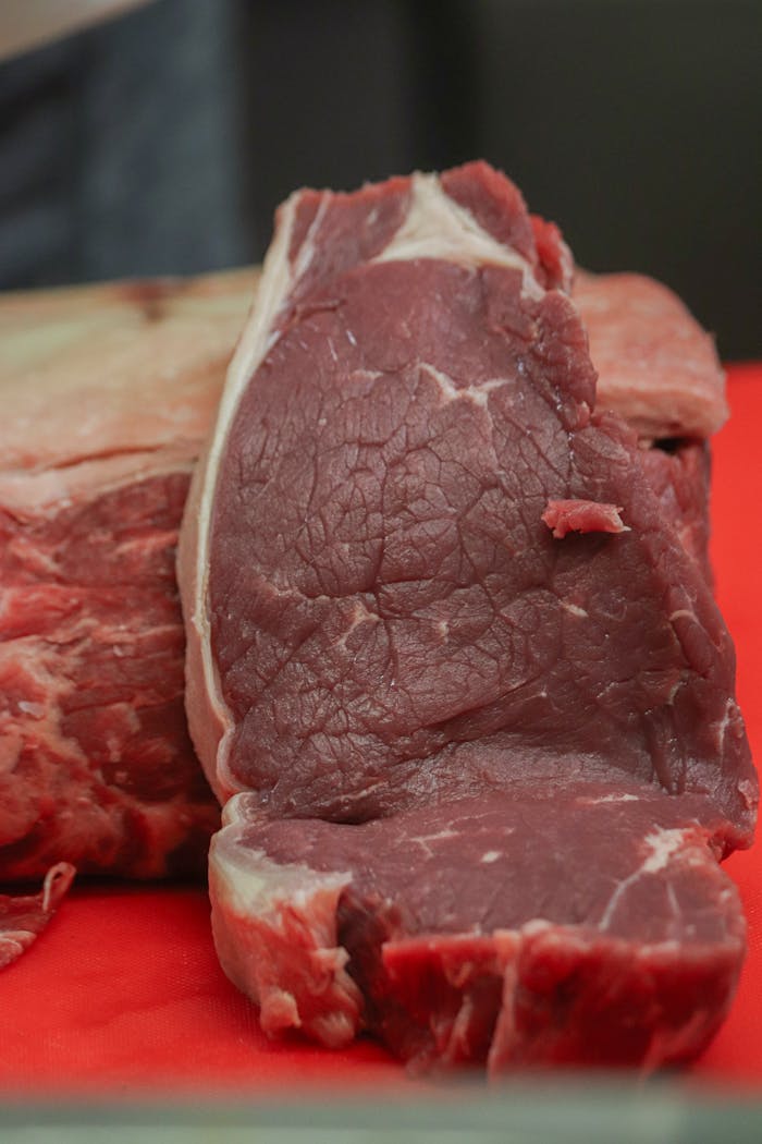 About Close-up of a raw steak on a red cutting board, ideal for food photography.