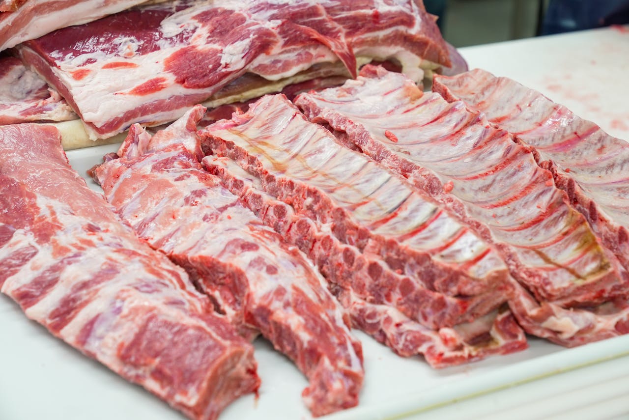 Home Close-up of fresh raw pork ribs neatly arranged on a cutting board, showcasing marbling.